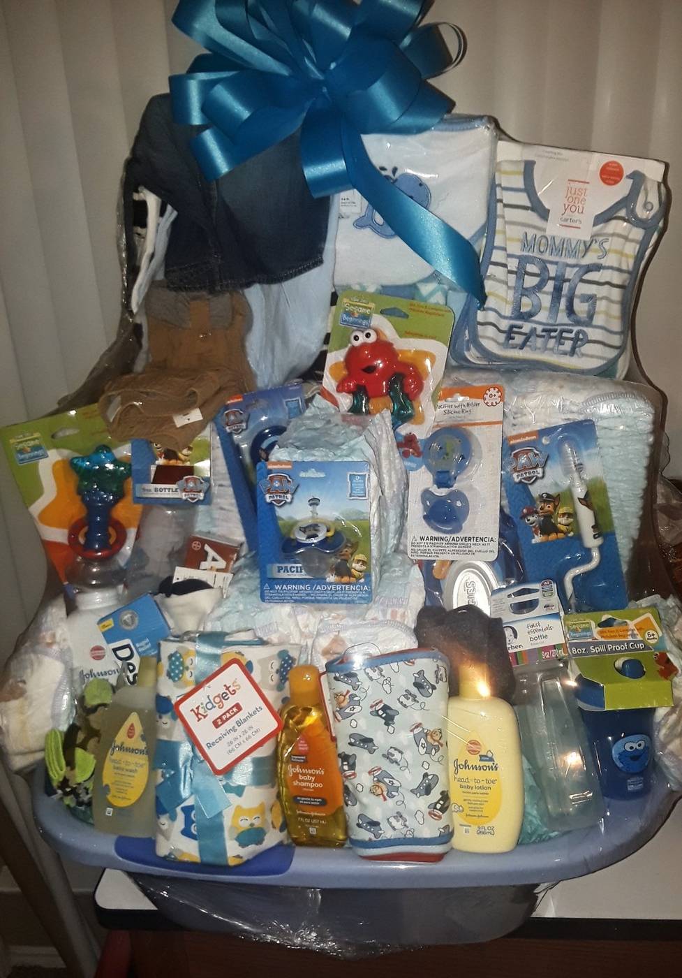 Giant baby shower gift basket with baby clothes, diapers, and baby essentials