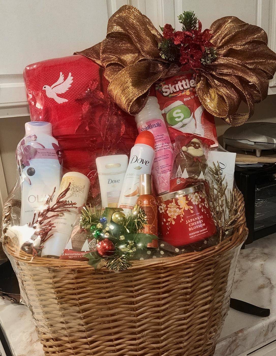 Christmas pamper basket with Dove, Olay, Bath & Body Works candle, and holiday decor