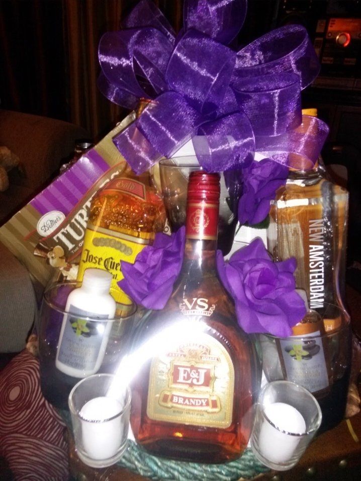 Men's spirits gift basket with brandy, tequila, vodka, candles, and snacks