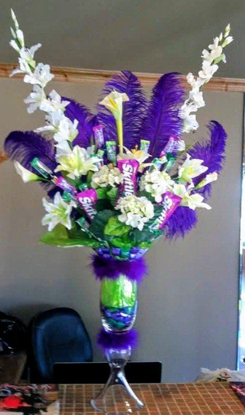 Skittles candy bouquet with purple feathers and white flowers