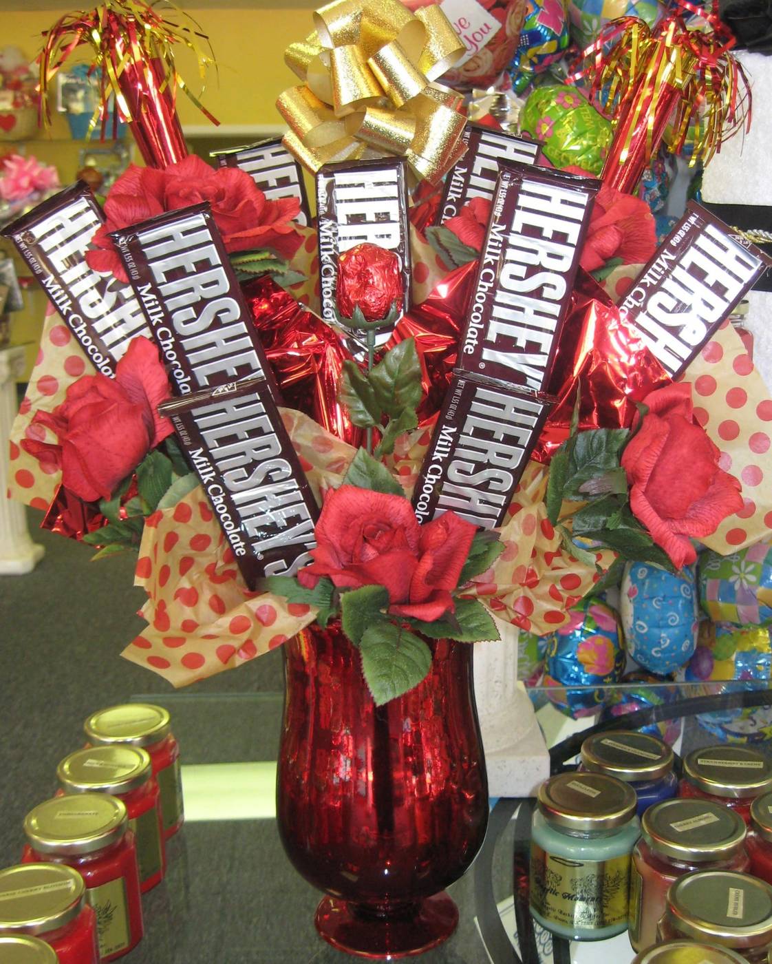 Hershey's chocolate bar bouquet with red roses in a red vase