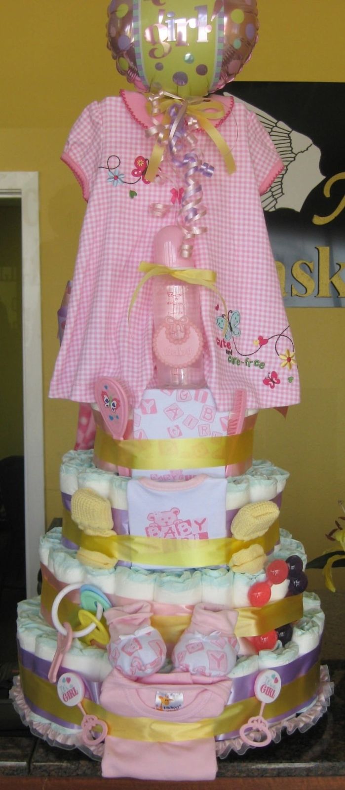 Pink baby girl diaper cake with dress, bottle and booties