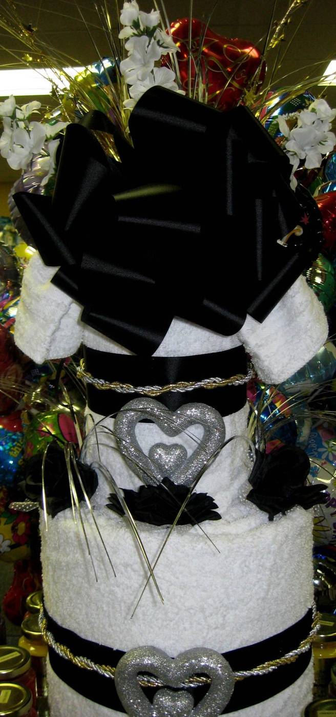 Black and silver towel cake with satin bow and glitter hearts