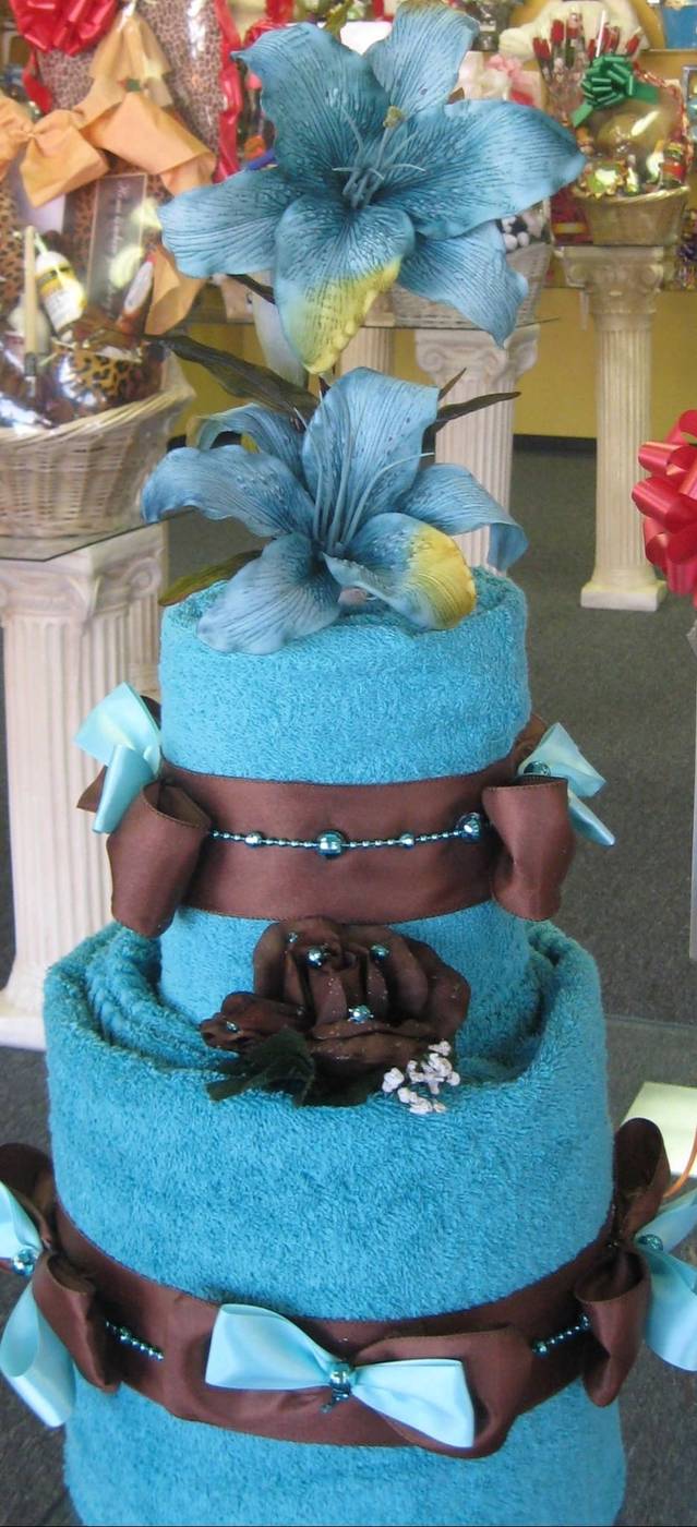 Turquoise towel cake with blue lilies and chocolate ribbon